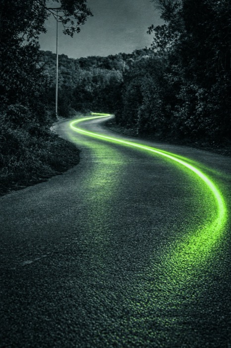 Estrada sinuosa iluminada por uma linha verde, ilustrando o caminho para implementar IA no marketing